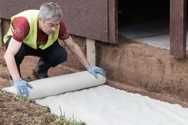 Геотекстиль под тротуарную плитку защищает основание от сорняков и смешивания слоев, а также увеличивает долговечность покрытия.